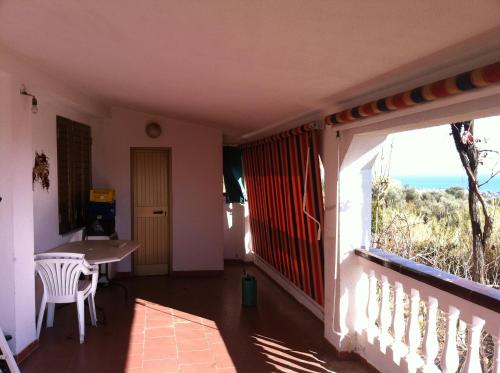 a room with a balcony with a table and a window at Rosa di Calabria in Bovalino Marina