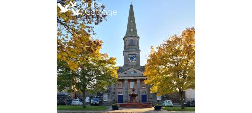 a building with a clock tower on top of it at Duke Cottage in Fochabers