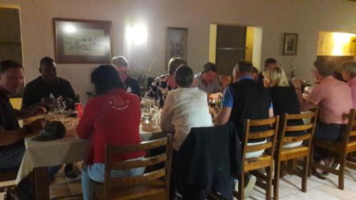 un grupo de personas sentadas en una mesa en un restaurante en Buschberg guest farm en Outjo