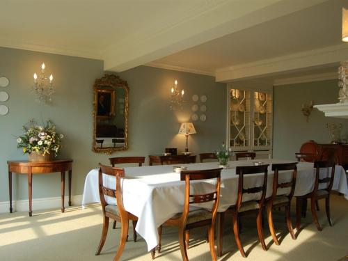 Manor Farm Egerton في Malpas: غرفة طعام مع طاولة بيضاء وكراسي