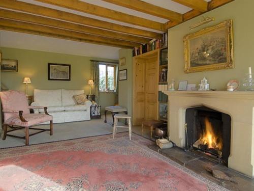 a living room with a fireplace and a white couch at Manor Farm Egerton in Malpas