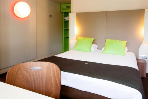 a small bedroom with two beds and a stool at Campanile Angers Ouest - Beaucouzé in Beaucouzé