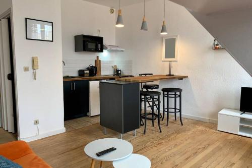 - un salon avec une cuisine et un bar avec des tabourets dans l'établissement Duplex Carcassonne centre, à Carcassonne