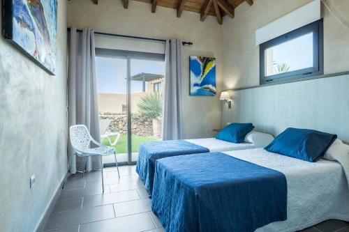 two beds in a room with a view of the ocean at Villa La Era 2 in Cotillo