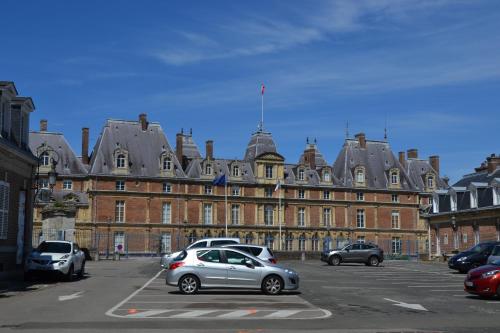 a large building with cars parked in a parking lot at B&B HOTEL Le Tréport Friville in Friville-Escarbotin