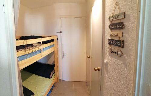 Cette chambre dispose de lits superposés avec 2 lits superposés et une porte. dans l'établissement Résidence Les Capitelles à Saint Cyprien avec accès direct plage- Balcon donnant Splendide vue Mer et Piscine, à Saint-Cyprien