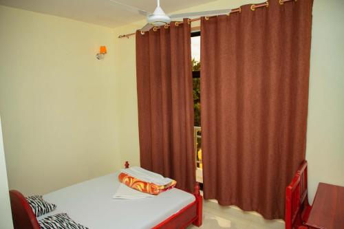 Postel nebo postele na pokoji v ubytování Kilimanjaro White House Hotel