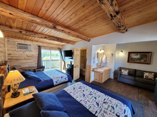 - une chambre avec deux lits et un canapé dans l'établissement Yellowstone Valley Inn, à Wapiti