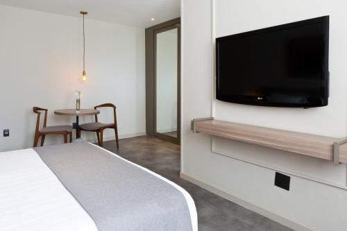 a hotel room with a flat screen tv on a wall at Ritz Leblon in Rio de Janeiro