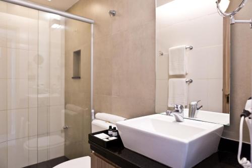 a bathroom with a sink and a shower and a toilet at Ritz Leblon in Rio de Janeiro