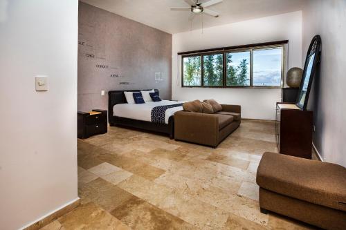 una camera con letto, divano e finestra di Capital O Cancun International Airport 24 p 7 a Cancún