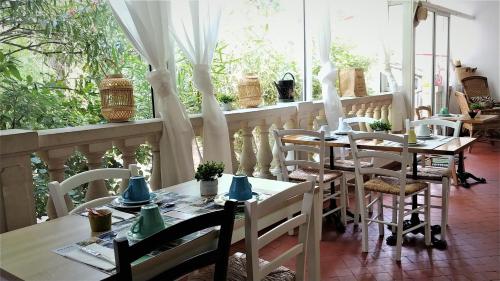 a dining room with tables and chairs and a window at Hôtel Le Victoria in Draguignan