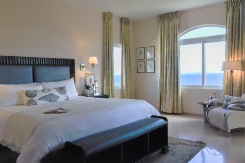 a bedroom with a large bed and a large window at Princess Heights Luxury Condo Hotel in Dawn Beach