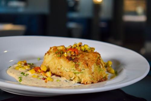 a plate of food with a piece of chicken and corn at Hotel Legends in Biloxi