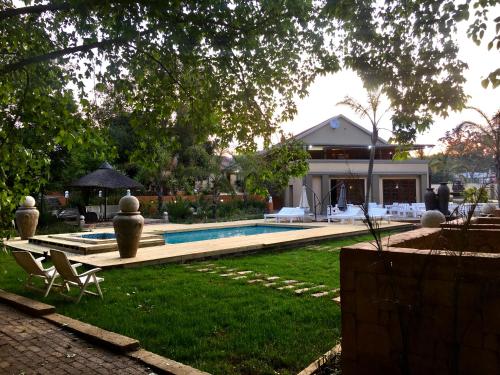 un cortile con piscina e una casa di The Afropolitan a Johannesburg