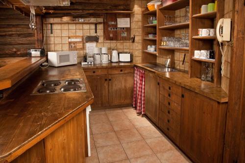 een keuken met houten kasten en een fornuis met oven bij Appartement Rossalm mit Sauna in Alpbach