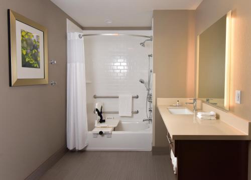 a bathroom with a tub and a sink and a shower at Staybridge Suites - Wisconsin Dells - Lake Delton, an IHG Hotel in Wisconsin Dells