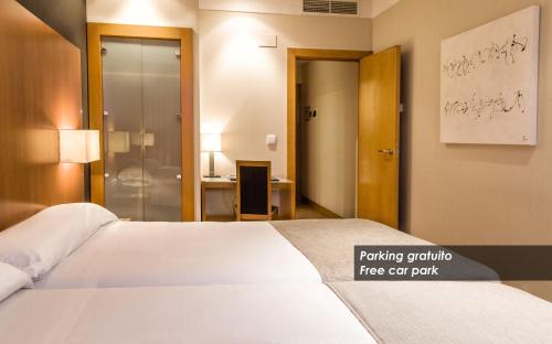 a hotel room with a bed and a bathroom at Zenit Logroño in Logroño