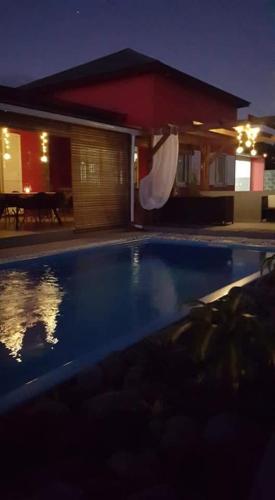 a swimming pool in front of a house at night at La kazanou in Saint-Joseph