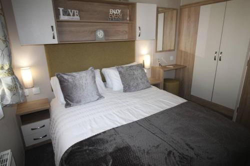 a bedroom with a large bed with two pillows at The One - Chalet in the Cairngorms in Boat of Garten