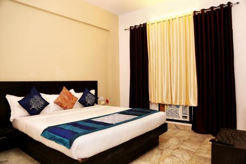 a bedroom with a large bed with blue pillows at Hotel Ace Plaza in Udaipur