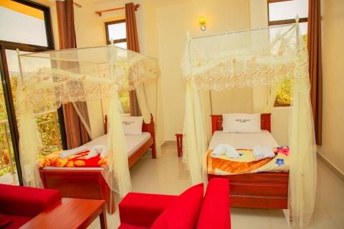 Postel nebo postele na pokoji v ubytování Kilimanjaro White House Hotel