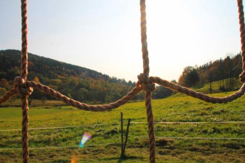a rope tied to a fence in a field at Domki pod Bukowym lasem in Wańkowa
