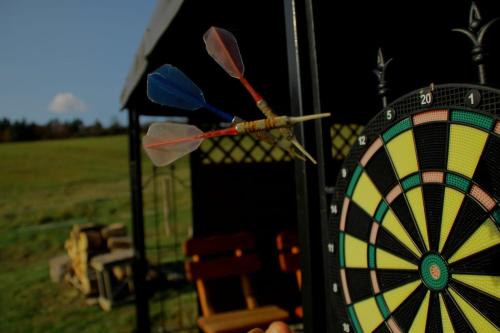 a dartboard with darts on a table in a field at Domki pod Bukowym lasem in Wańkowa
