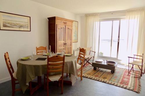 une salle à manger avec une table et des chaises et une fenêtre dans l'établissement La Corniche, à Agon-Coutainville