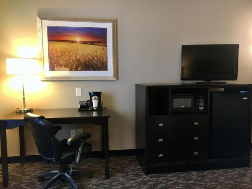 a hotel room with a desk and a television at Best Western Wheatland Inn in Colfax