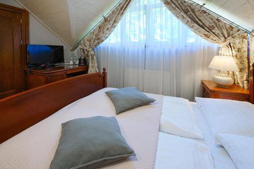 a bedroom with a bed with two pillows on it at Hotel Zalesie in Bochnia