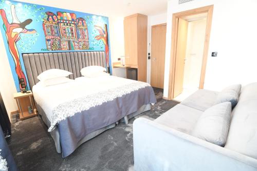 a hotel room with two beds and a couch at Hotel Aida Opera in Paris