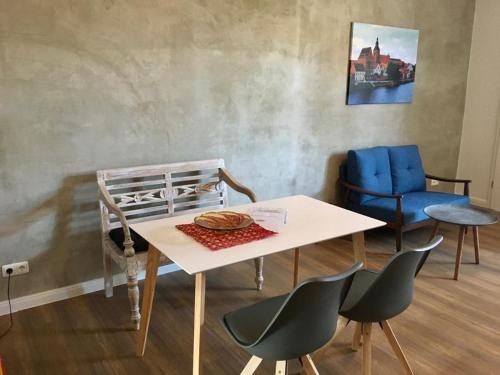 Bilderbuchcafe - Ferien Apartment NO 5 - Markt 7 في هافلبرغ: غرفة بها طاولة وكراسي زرقاء