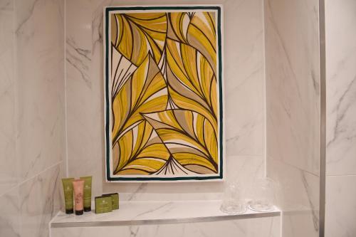 a painting on a wall above a shelf in a bathroom at Hotel Aida Opera in Paris