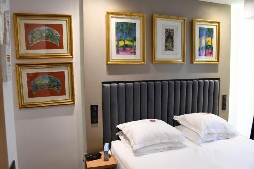 a hotel room with a bed and a painting on the wall at Hotel Aida Opera in Paris