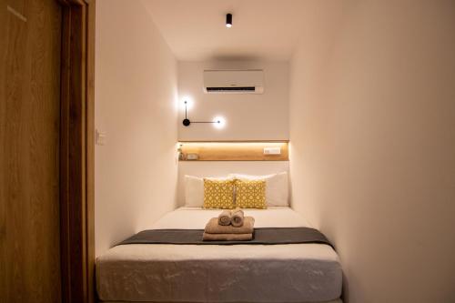 a small bedroom with a bed with a towel on it at Phaedrus Living Seaview Studio Suite Lighthouse 52 in Paphos City