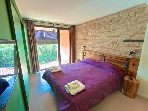 a bedroom with a purple bed with two towels on it at Hotel Restaurant Lotus Priorat in Falset