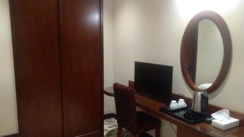 a hotel room with a mirror and a desk with a computer at رميس البخاري in Buraydah