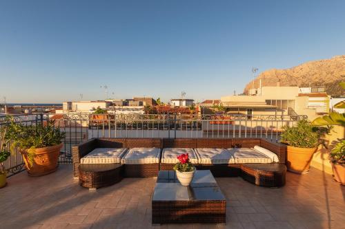 a patio with couches and tables on a balcony at Casa Manzella in Terrasini