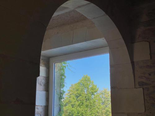 a window in a building with a view of a tree at Château de la Garnison in Orvault