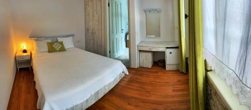 a bedroom with a white bed and a wooden floor at Oberj d'Azur Alaçatı in Alaçatı