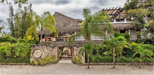 an exterior view of a resort with palm trees at Hotel Aires Bacalar in Bacalar