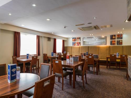 a restaurant with tables, chairs, and tables in it at Holiday Inn Express London Gatwick Crawley, an IHG Hotel in Crawley