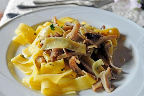 a plate of pasta with mushrooms on a table at Sa Mola in Bonarcado