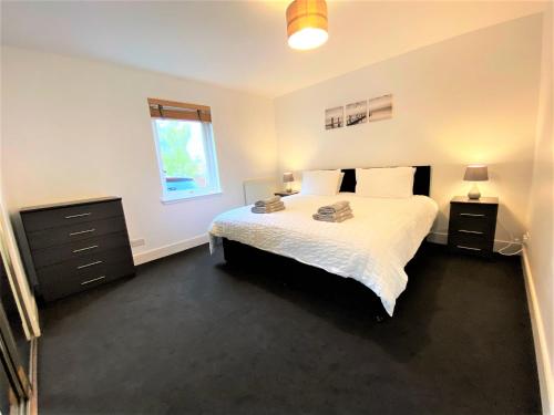 a bedroom with a white bed and a window at Grampian Serviced Apartments - Garden Neuk - Lesmurdie House in Elgin