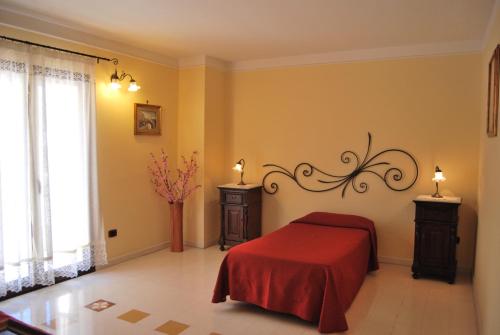 a bedroom with a bed with a red blanket at Casa Manzella in Terrasini