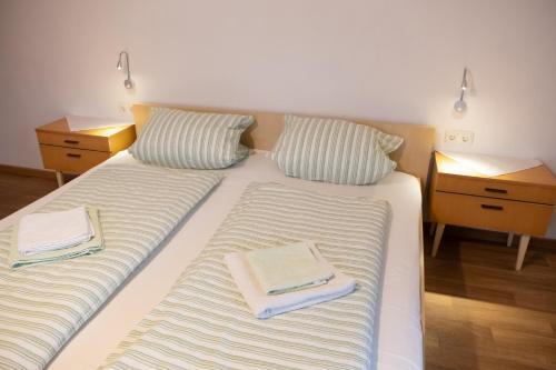 a large white bed with two towels on it at Haus Alpenrose in Obertraun