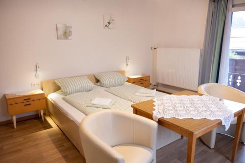 Kleines Zimmer mit einem Bett und einem Tisch in der Unterkunft Haus Alpenrose in Obertraun