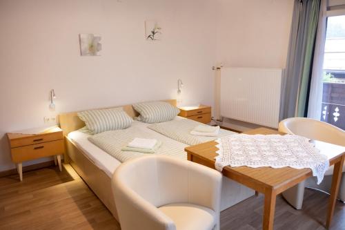 a small room with a bed and a table at Haus Alpenrose in Obertraun
