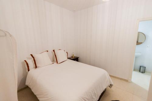 ein Schlafzimmer mit einem weißen Bett mit zwei Kissen in der Unterkunft Apartamento - Casa Habanera in Cádiz